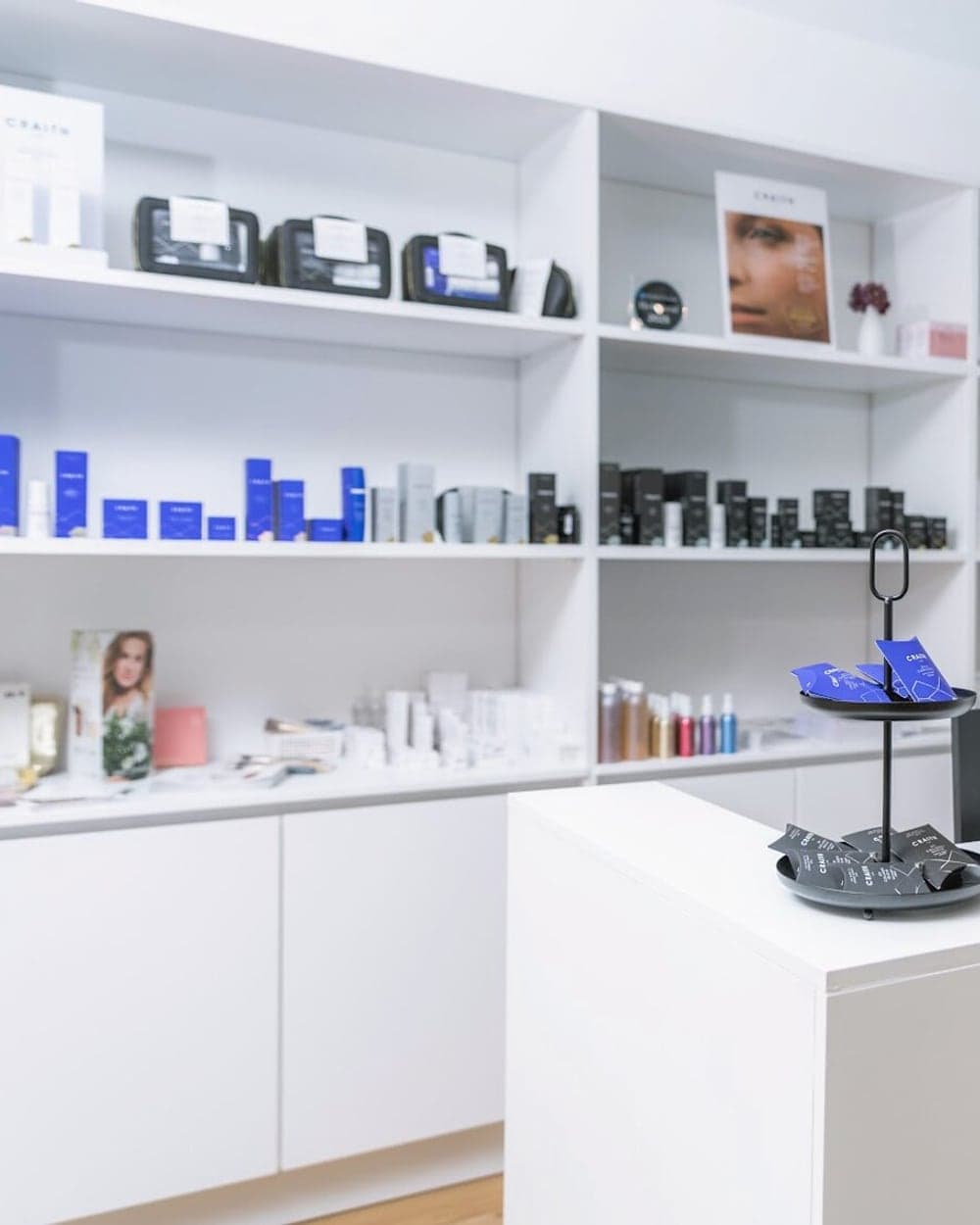 Produktregal im Beautyloft mit Pflegeserien vor dem hellen Empfangstresen