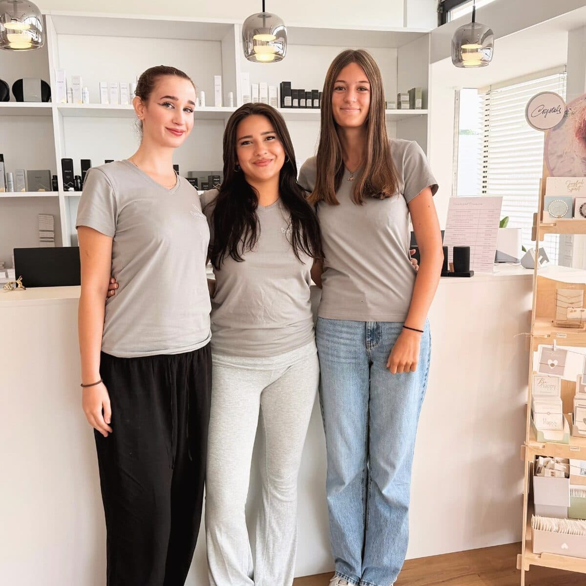 Drei Auszubildende des Beautyloft im Institut vor dem Produktregal