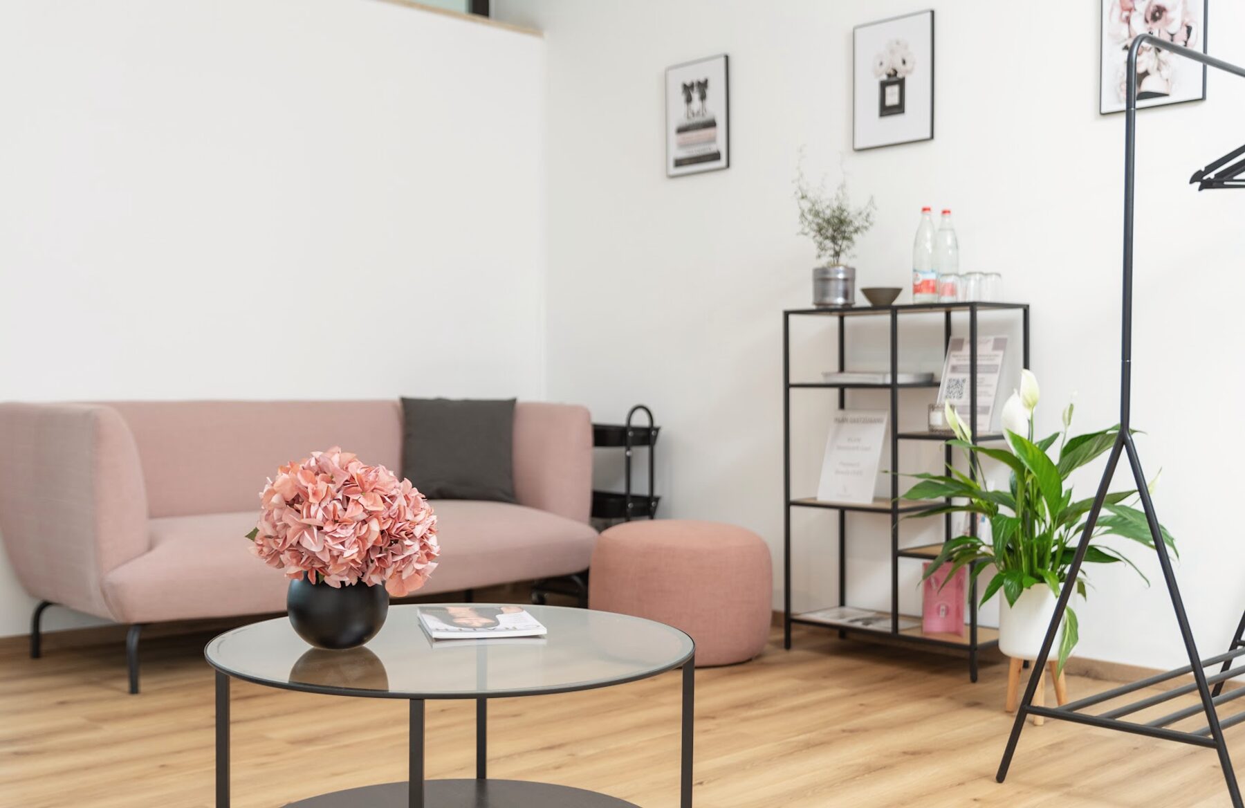 Wartebereich im Beautyloft mit altrosa Sofa, Hortensien und Produktregal